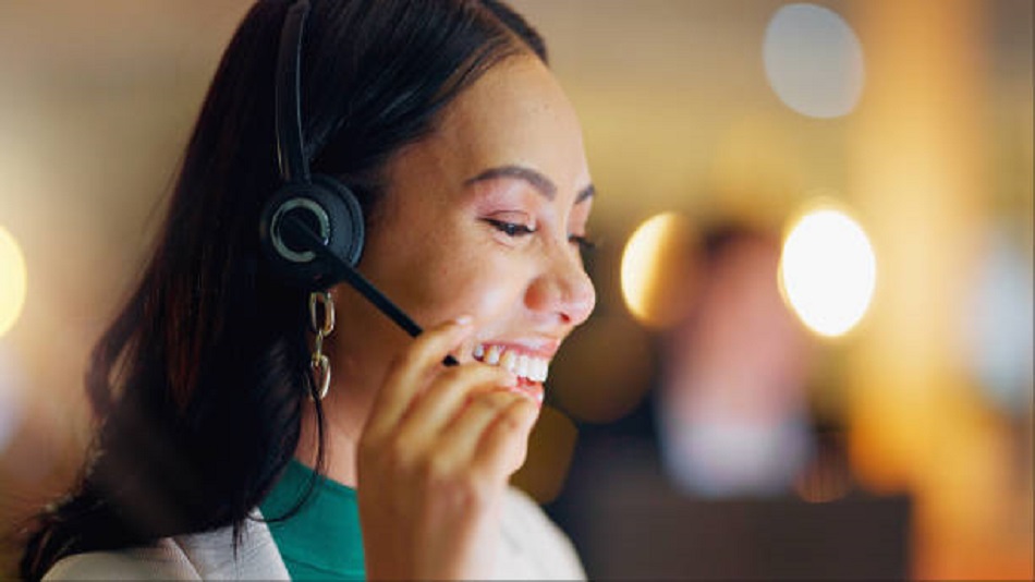 une femme souriante qui prend un appel dans un centre d'appels - la permanence téléphonique - Optiserv