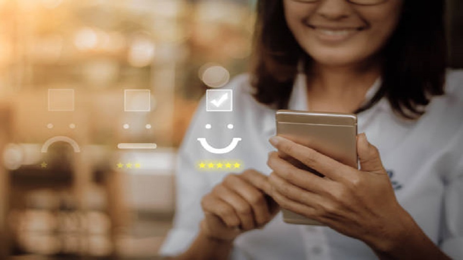 Femme d'affaires appuyant sur l'émoticône du visage sur l'écran tactile virtuel d'un smartphone - assurer un service de permanence téléphonique - Opriserv