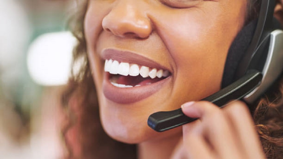 une femme souriante au téléphone - assurer un service de permanence téléphonique - Optiserv