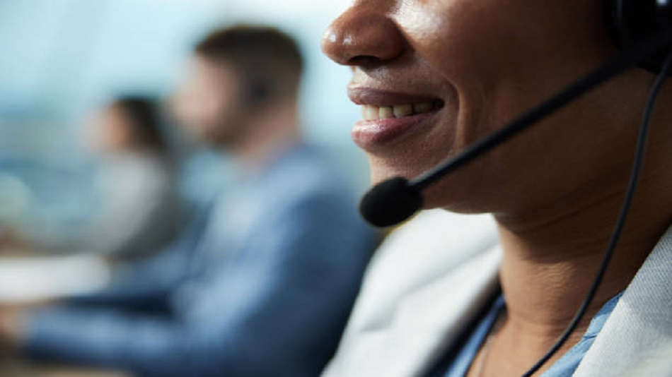 une femme parlant au casque dans un centre d'appels - relation client - Optiserv